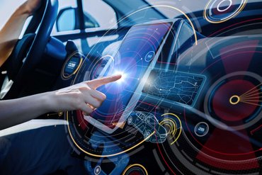 Hand touches futuristic display in a car